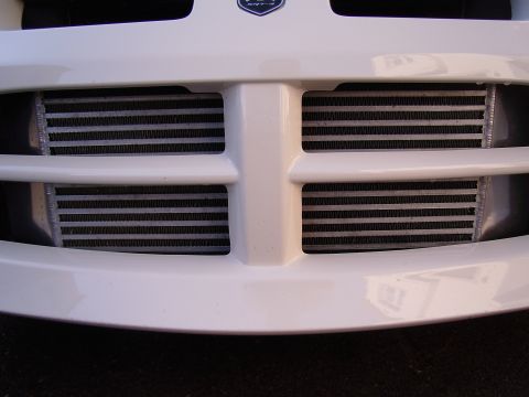 1996 Ford Probe - Close-up of a white car's front grille, revealing two prominent intercoolers behind the horizontal bars.