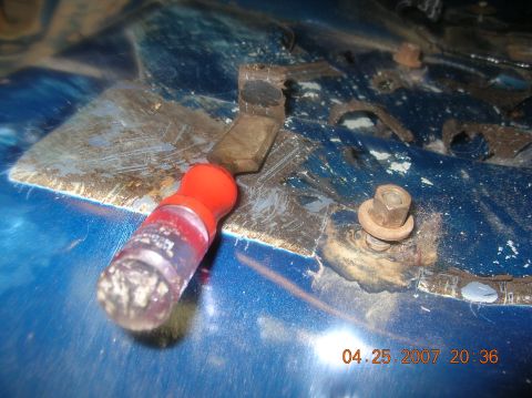 1991 Ford F-150 - A close-up view shows a metal bracket and a screwdriver on a blue surface with visible rust and wear.