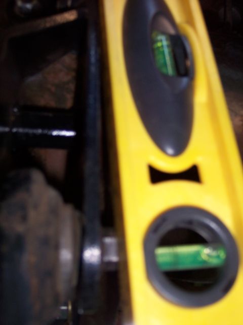 1996 Ford Bronco - A yellow level tool is positioned against a dark vehicle component, with its bubble indicating a measurement.