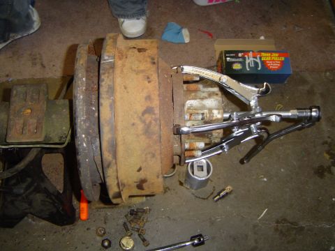 1978 Ford Bronco - A gear puller is used to remove a heavily rusted brake drum assembly from a vehicle part.