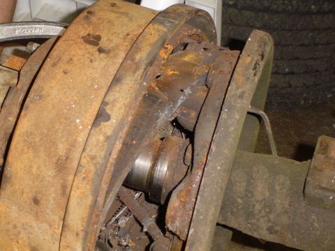 1978 Ford Bronco - This image shows a severely corroded vehicle axle component, likely a brake drum, with visible damage.
