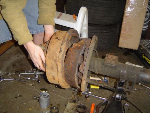 1978 Ford Bronco - Close-up of a heavily rusted brake drum and assembly on a vehicle axle.