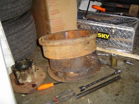 1978 Ford Bronco - A collection of heavily rusted automotive parts and tools are laid out on a concrete floor.