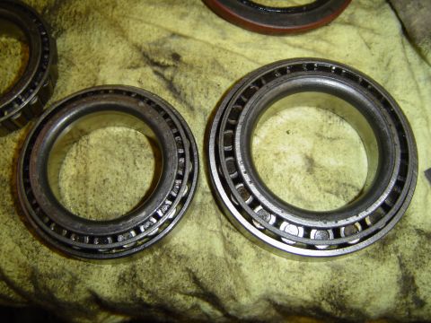 1978 Ford Bronco - Two metal wheel bearings with rollers are shown on a yellow cloth.