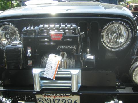 1987 Suzuki Samurai - Front view of a black Jeep Wrangler a WARN PowerPlant HP winch and a chrome bumper with a license plate.