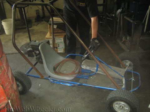 1987 Suzuki Samurai - A person is standing next to a homemade go-kart in a workshop.