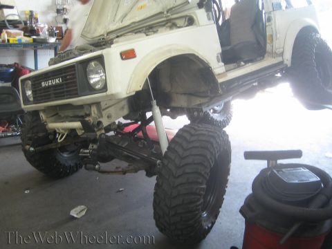 1987 Suzuki Samurai - Suzuki Samurai undergoing suspension modifications, showing off its lifted stance and large tires.