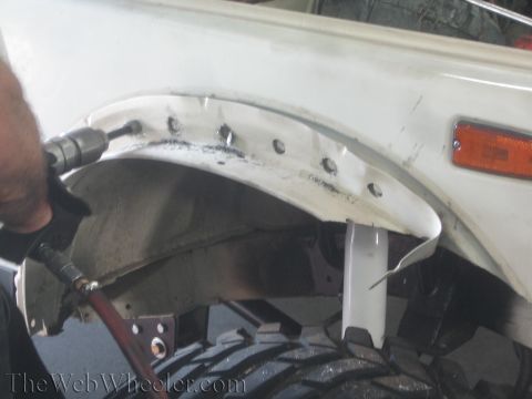 1987 Suzuki Samurai - Modifying a vehicle's fender with a drill and air tool, preparing for a suspension upgrade.