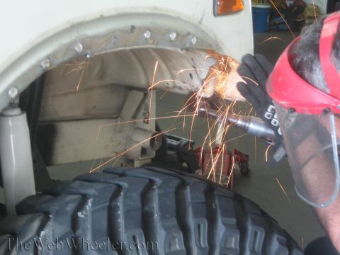 1987 Suzuki Samurai - Grinding metal on a vehicle's wheel well during a modification project.