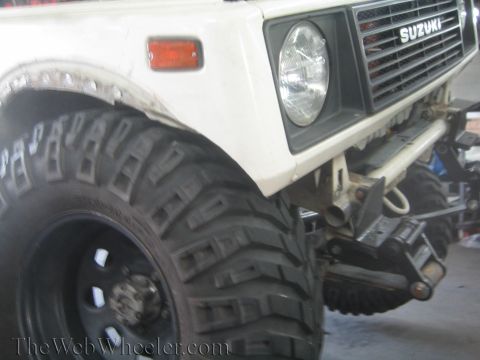 1987 Suzuki Samurai - Front quarter view of a 1987 Suzuki Samurai, large off-road tires and the Suzuki badge on the grille.
