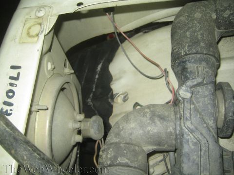 1987 Suzuki Samurai - Close-up view of engine bay components including a pump and wiring. Some text is visible on the white panel.