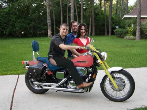 1989 Ford Bronco - Three people pose on a motorcycle with a red fuel tank and yellow front forks.