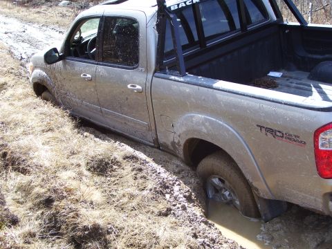 1996 Ford Bronco - This Toyota Tundra TRD Off Road is stuck deep in the mud, showing its side profile.