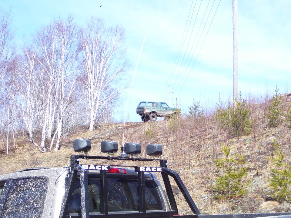 Green 1996 Ford Bronco 3/4 front view on a grassy hill
