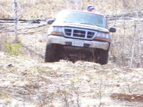 1996 Ford Bronco - A Ford Ranger navigates a rough, wooded terrain.