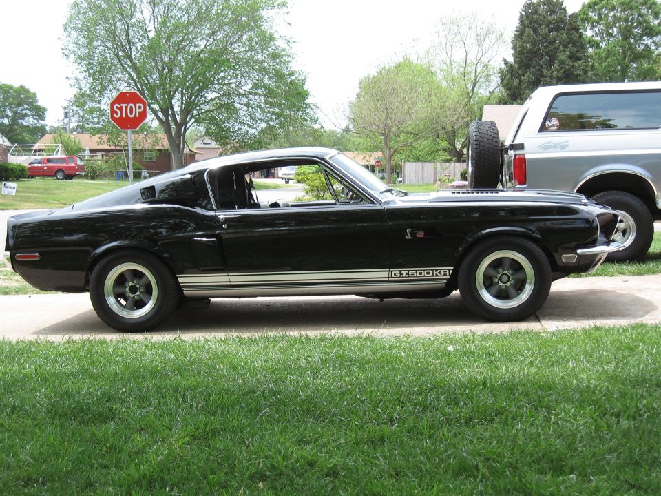 Black 1968 Shelby GT500KR parked next to a silver Ford Bronco