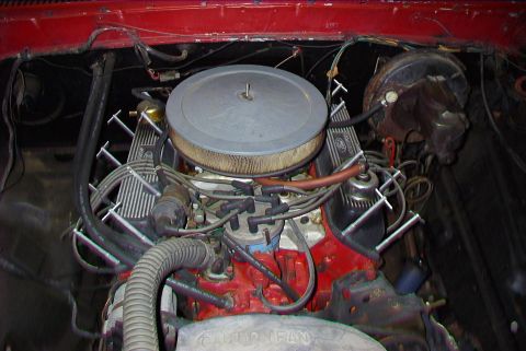 1979 Ford F-150 - The engine bay of a 1979 Ford F-150 shows its V8 engine, complete with an air cleaner and various hoses and wires.