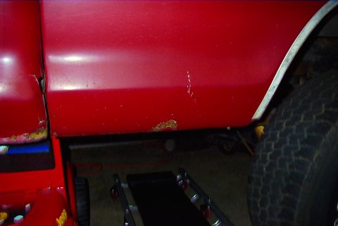 1979 Ford F-150 - Rust is visible on the lower body panel of a red vehicle, with another vehicle in the foreground.
