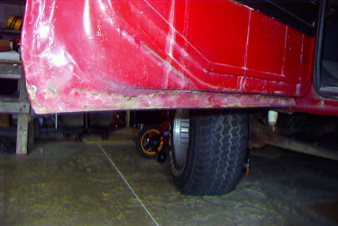 1979 Ford F-150 - Close-up of the lower door panel and wheel well on a red 1979 Ford F-150.