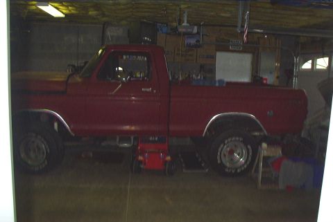 1979 Ford F-150 - This red 1979 Ford F-150 pickup truck is viewed from the side, possibly in a garage or workshop.
