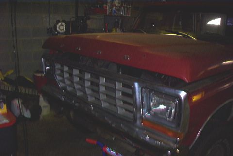1979 Ford F-150 - Front end of a red 1979 Ford F-150 pickup truck, showing the grille and headlights.