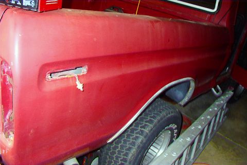 1979 Ford F-150 - Rear quarter panel of a red 1979 Ford F-150 pickup truck, showing a missing tail light assembly.