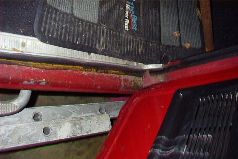1979 Ford F-150 - The interior door sill of a truck shows signs of rust and wear, with floor mats visible above.