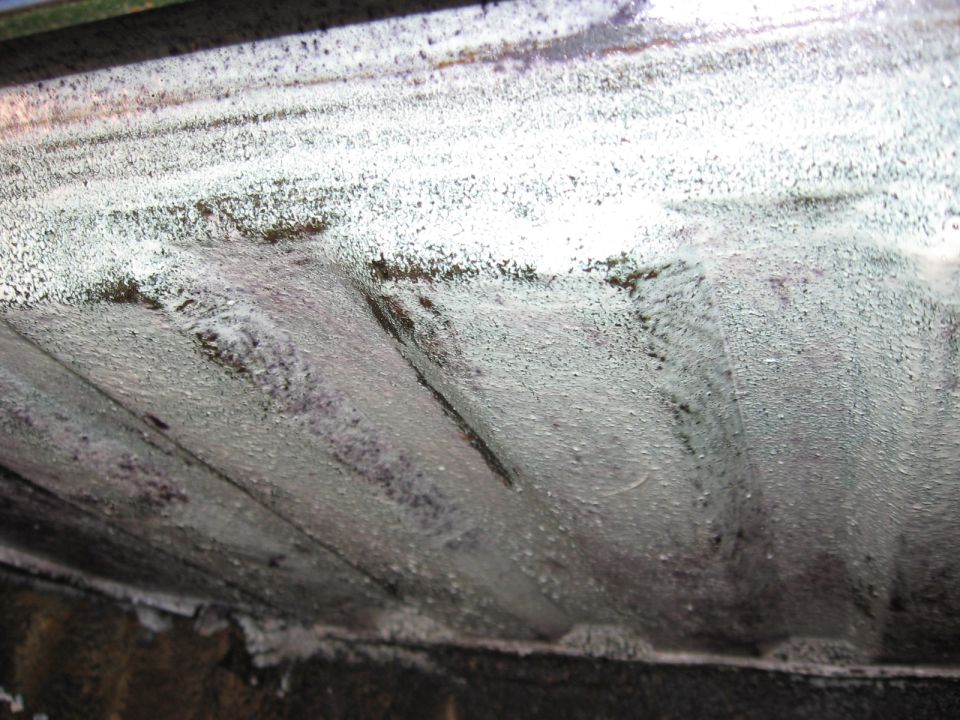 Underside of a vehicle with ribbed metal panels coated in white material