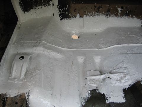 1973 Ford Ranchero - Undercarriage of a vehicle after undercoating application, revealing structural details.