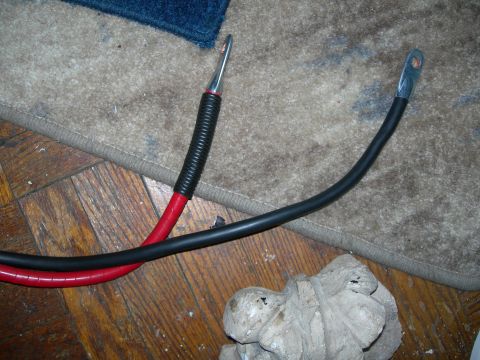 1992 Ford Taurus - Close-up of two battery cables, one red and one black, with metal ring terminals.