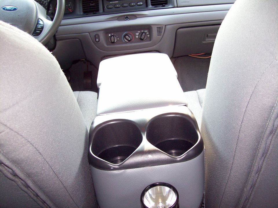 Gray aftermarket center console with dual cupholders between front seats of a Ford Crown Victoria interior