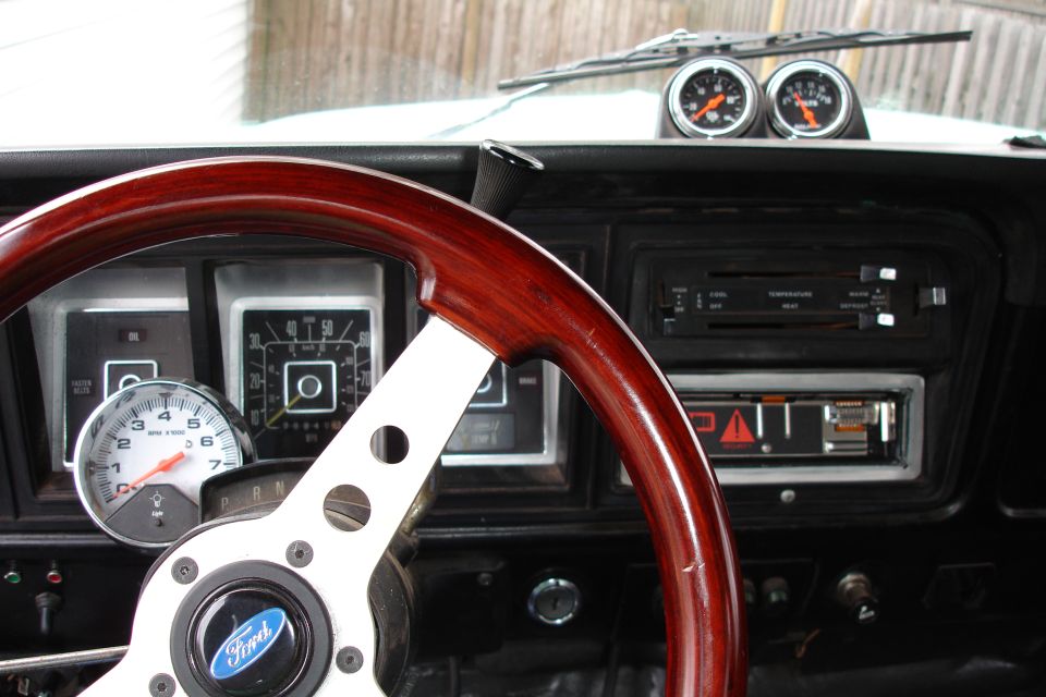 Truck dashboard with wood steering wheel and gauges