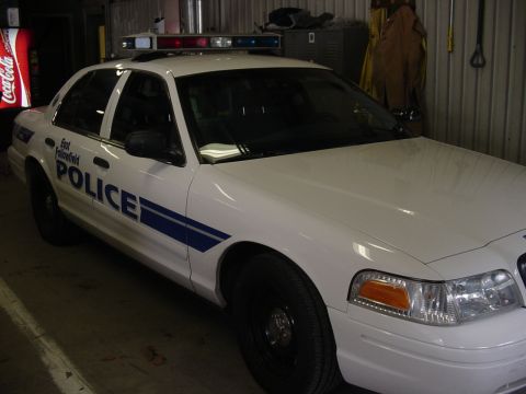 2002 Ford Crown Victoria - A white 2002 Ford Crown Victoria police car is parked indoors, a light bar on the roof and "East Fallowfield POLICE" text on the door.