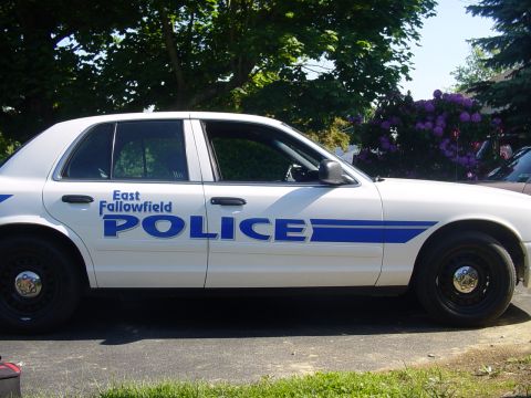 2002 Ford Crown Victoria - White 2002 Ford Crown Victoria police car with blue markings on the side.