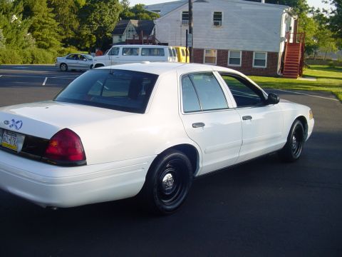 2002 Ford Crown Victoria - This white 2002 Ford Crown Victoria is shown from the rear quarter angle, with police markings removed.