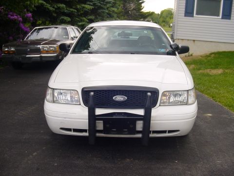 2002 Ford Crown Victoria - Front view of a white 2002 Ford Crown Victoria, parked next to another car.
