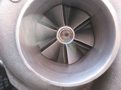 1996 Ford Probe - Close-up view of a turbocharger's compressor wheel, showing its angled blades and metallic housing.