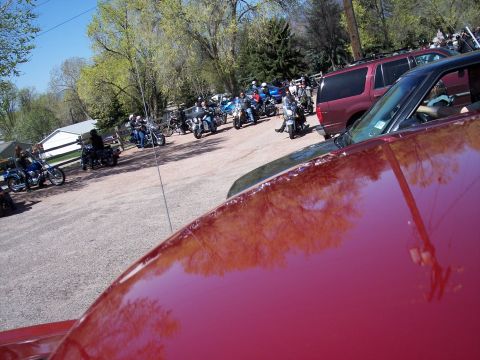 1972 Ford Ranchero - A group of motorcycles and SUVs are gathered in a gravel lot on a sunny day.