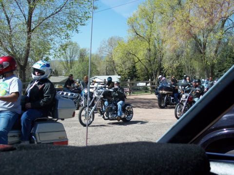 1972 Ford Ranchero - A group of motorcyclists are gathered in a parking lot on a sunny day.