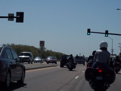 1972 Ford Ranchero - A procession of motorcycles and cars travels down a highway under a clear blue sky.