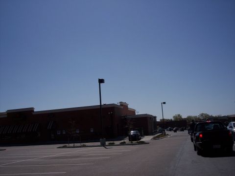 1972 Ford Ranchero - A parking lot scene with a brick building and multiple vehicles under a clear blue sky.