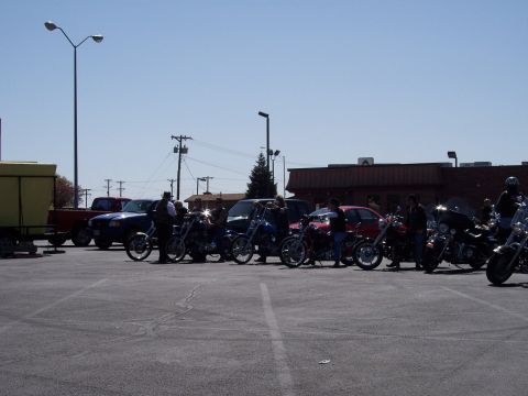 1972 Ford Ranchero - A group of motorcycles and cars are parked in a lot on a sunny day.