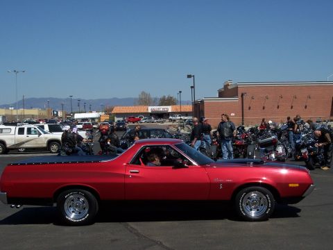 1972 Ford Ranchero - A group of people and motorcycles gather around a red 1972 Ford Ranchero in a parking lot.
