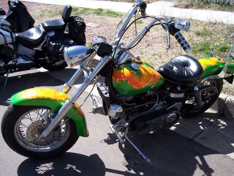 1972 Ford Ranchero - A custom motorcycle with a green and orange flame paint job is parked next to another motorcycle.