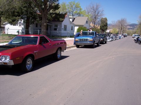1972 Ford Ranchero - A red 1972 Ford Ranchero with a black hood is parked on a residential street alongside other vehicles and motorcycles.