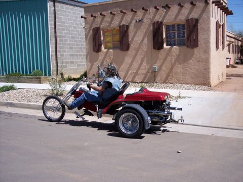 1972 Ford Ranchero - A custom trike is parked on the side of the road in front of a building.