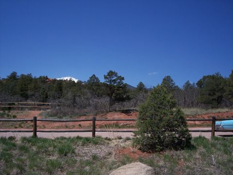 1972 Ford Ranchero - A scenic view of a mountain range under a clear blue sky, with trees and a fence in the foreground.
