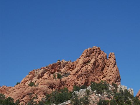 1972 Ford Ranchero - A large, textured red rock formation dominates the landscape under a bright blue sky.
