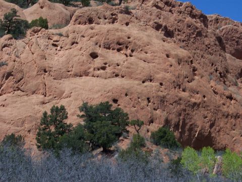 1972 Ford Ranchero - A natural rock formation displays a textured surface with many small holes, set against a clear blue sky.