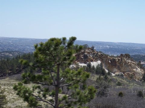 1972 Ford Ranchero - View of a rocky landscape with scattered trees and a town in the distance under a bright sky.